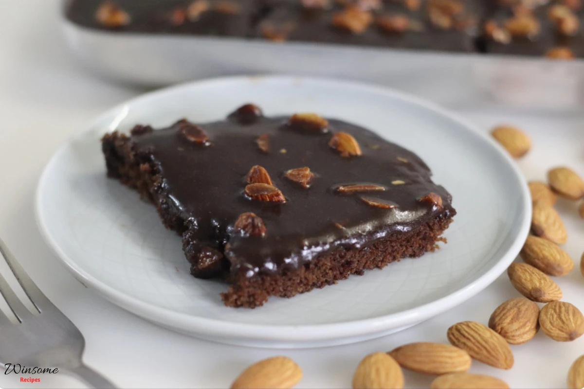 A slice of Texas Sheet Cake Recipe topped with nuts, showcasing rich chocolate layers and a decadent frosting.