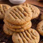 Peanut Butter Cookie recipe cooling on a rack, golden brown and delicious, ready to be enjoyed from a homemade recipe.