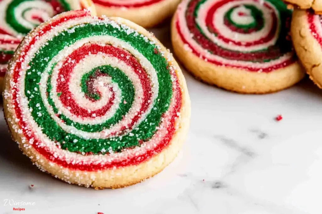 A close-up of a pinwheel cookie featuring vibrant red, green, and white swirls, showcasing its festive design.