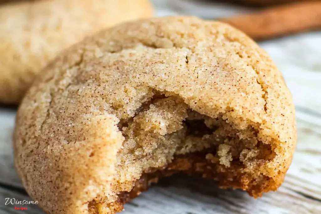 Cinnamon sugar cookie with a bite taken out, showcasing its soft texture and sweet, spiced flavor. Perfect for dessert!