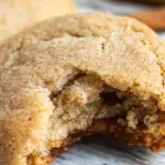 Cinnamon sugar cookie with a bite taken out, showcasing its soft texture and sweet, spiced flavor. Perfect for dessert!