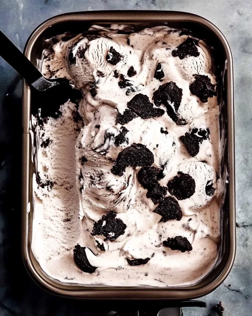 A delicious ice cream dish filled with cookies and cream ice cream topped with crunchy Oreo cookie pieces.