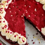 red velvet cookie cake recipe with a slice removed, showcasing its rich color and creamy frosting, perfect for a delightful dessert.