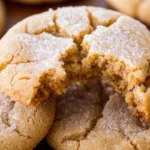 A close-up of a brown sugar cookie with a bite taken out, showcasing its soft texture and delicious golden color.
