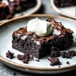 A delicious plate of One Bowl Brownies topped with fluffy whipped cream, ready to be enjoyed.