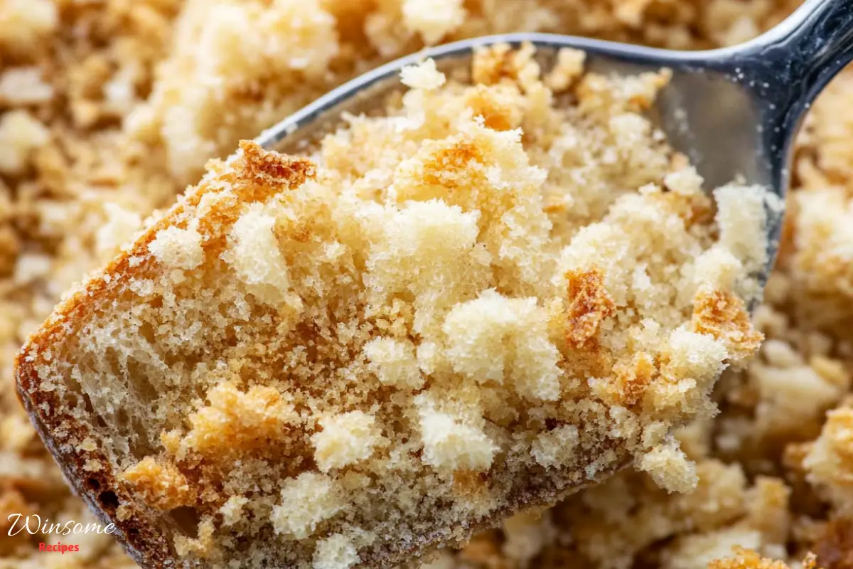 A spoonful of cake topped with crumbs, showcasing a delightful blend of textures and flavors.