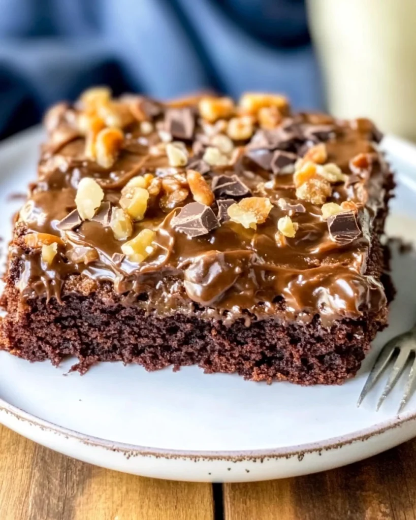 A slice of German chocolate sheet cake topped with crunchy nuts, showcasing rich chocolate layers and a delightful texture.
