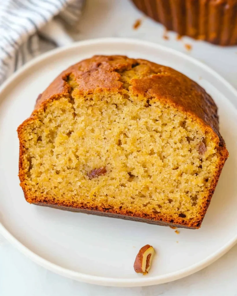 Sliced sweet potato banana bread arranged neatly on a white plate, showcasing its moist texture and inviting appearance.