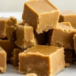 A tempting pile of easy peanut butter fudge squares on a clean white surface, ready to be enjoyed.