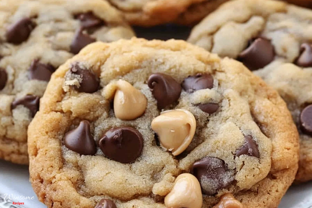 Caramel chocolate chip cookies topped with peanuts and chocolate chips, arranged on a white plate.