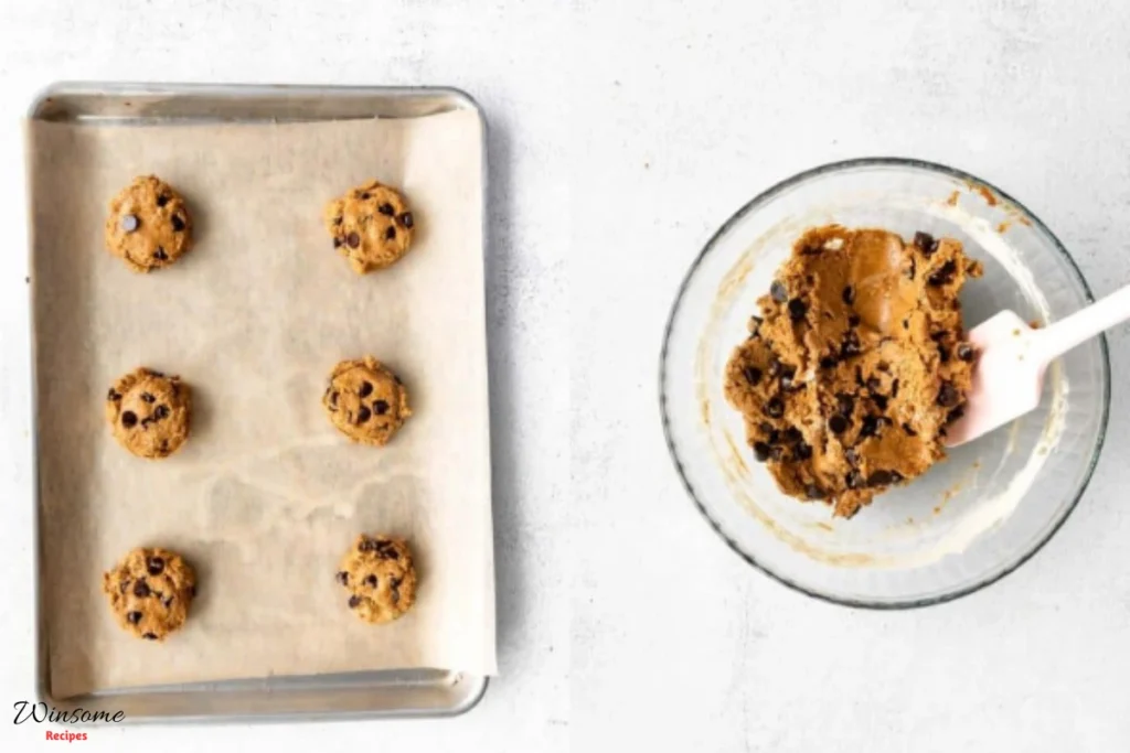 Baking sheet filled with protein chocolate chip cookies, golden brown and freshly baked, ready to be enjoyed.